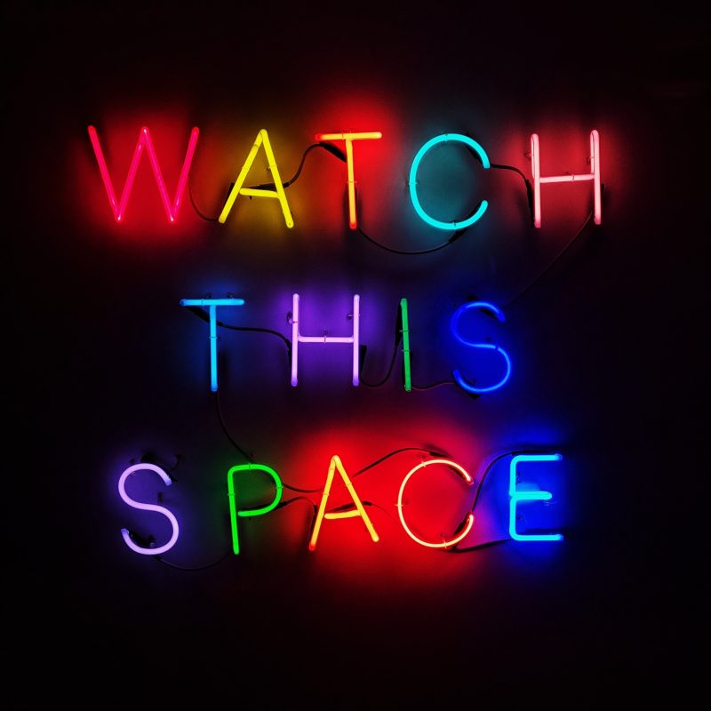 multi coloured neon sign that says 'watch this space'